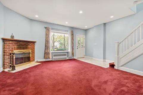 a view of an empty room with a fireplace and a window