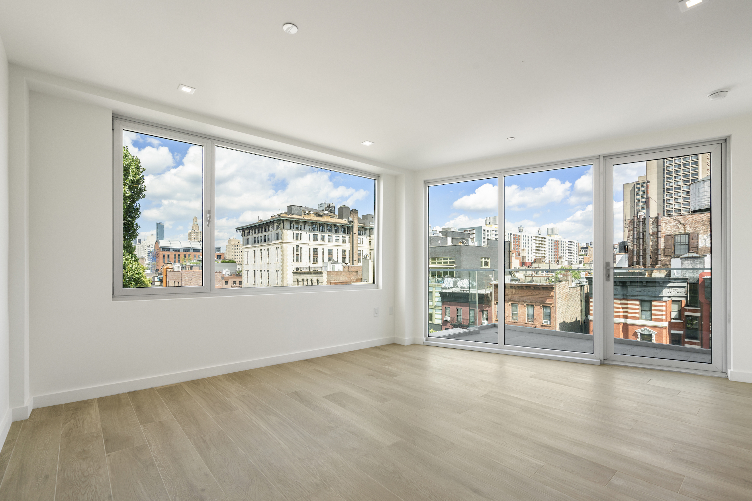 136 West Houston Street, Unit PH Manhattan, NY 10012 - Photo 18 of 26 an empty room with wooden floor and windows