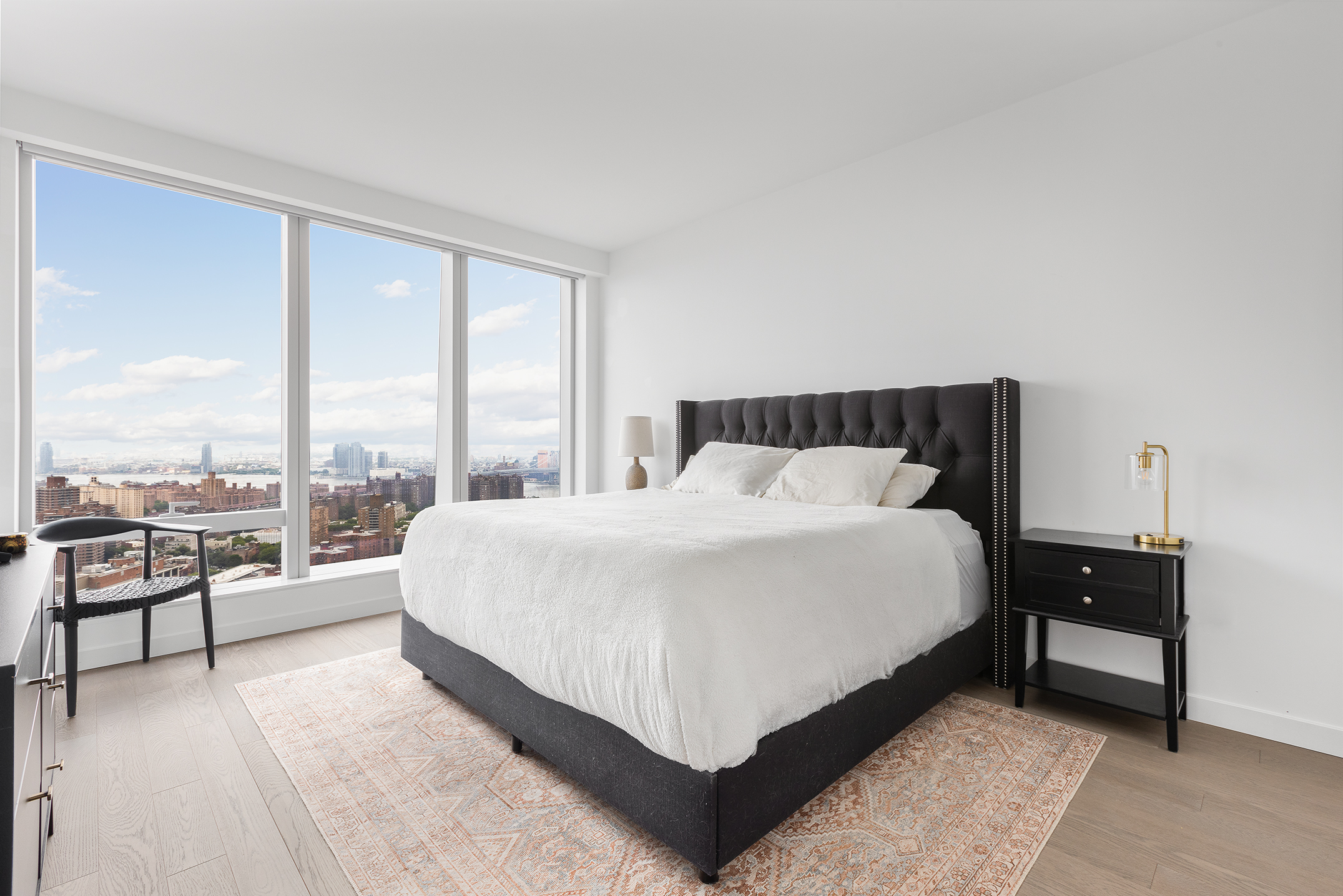 252 South Street, Unit 42K Manhattan, NY 10002 - Photo 2 of 6 a large bed sitting in a bedroom next to a window