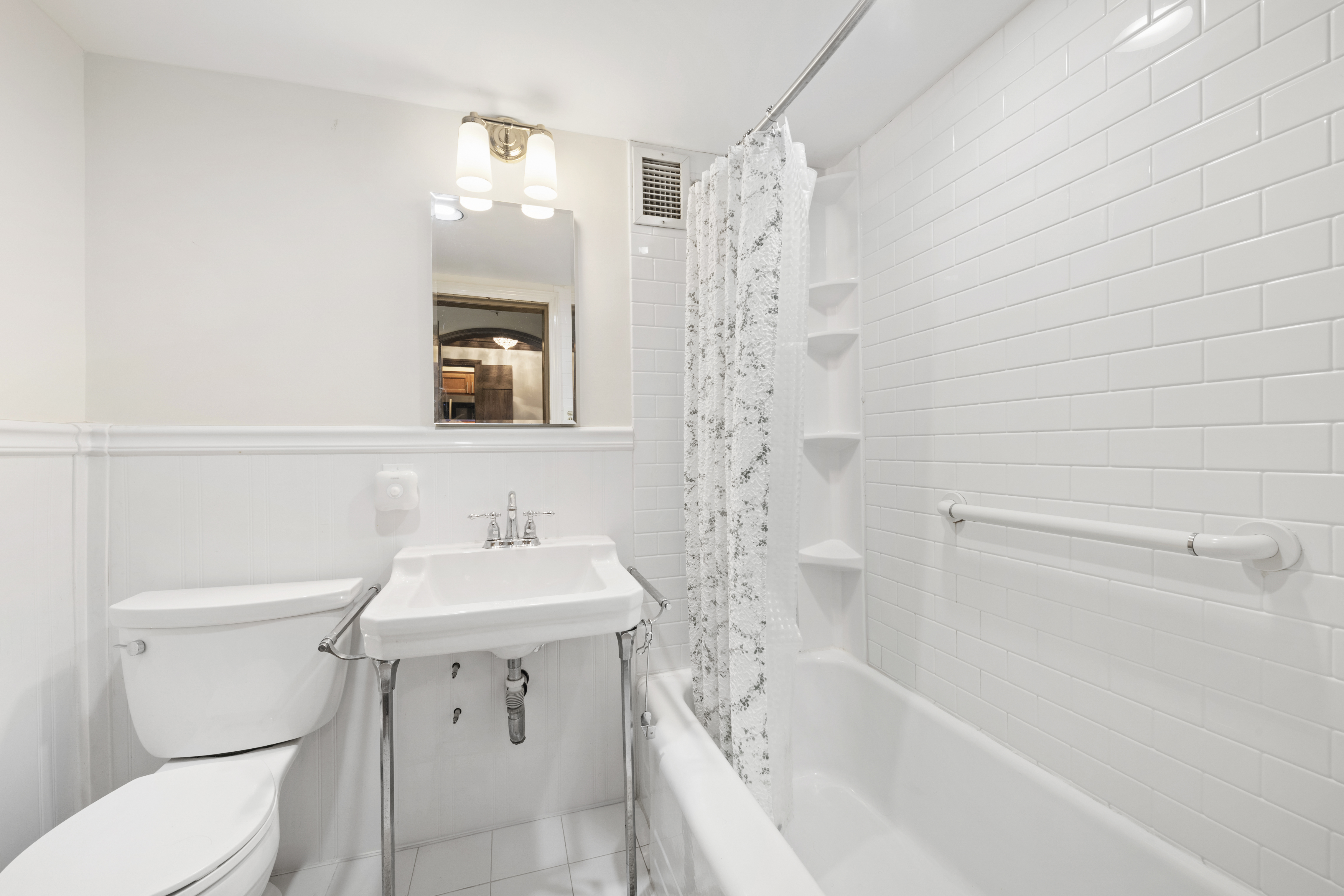 110 East 57th Street, Unit 16B Manhattan, NY 10022 - Photo 12 of 15 a bathroom with a sink a toilet and shower