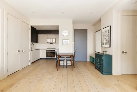 a kitchen with a table chairs refrigerator and cabinets
