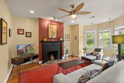 a living room with furniture a fireplace and a potted plant