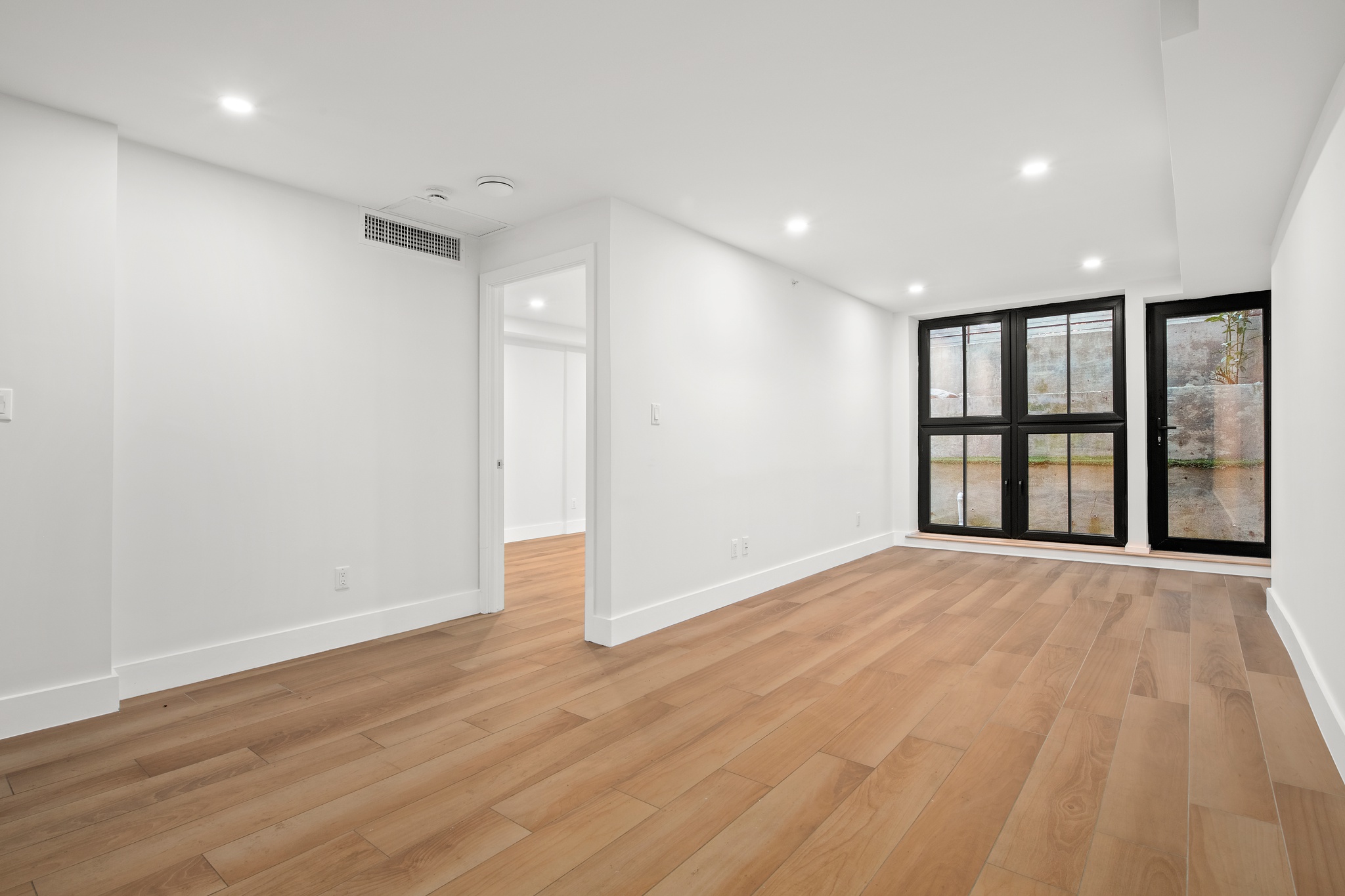277 Greene Avenue, Unit B Brooklyn, NY 11238 - Photo 2 of 13 a view of an empty room with a window and wooden floor