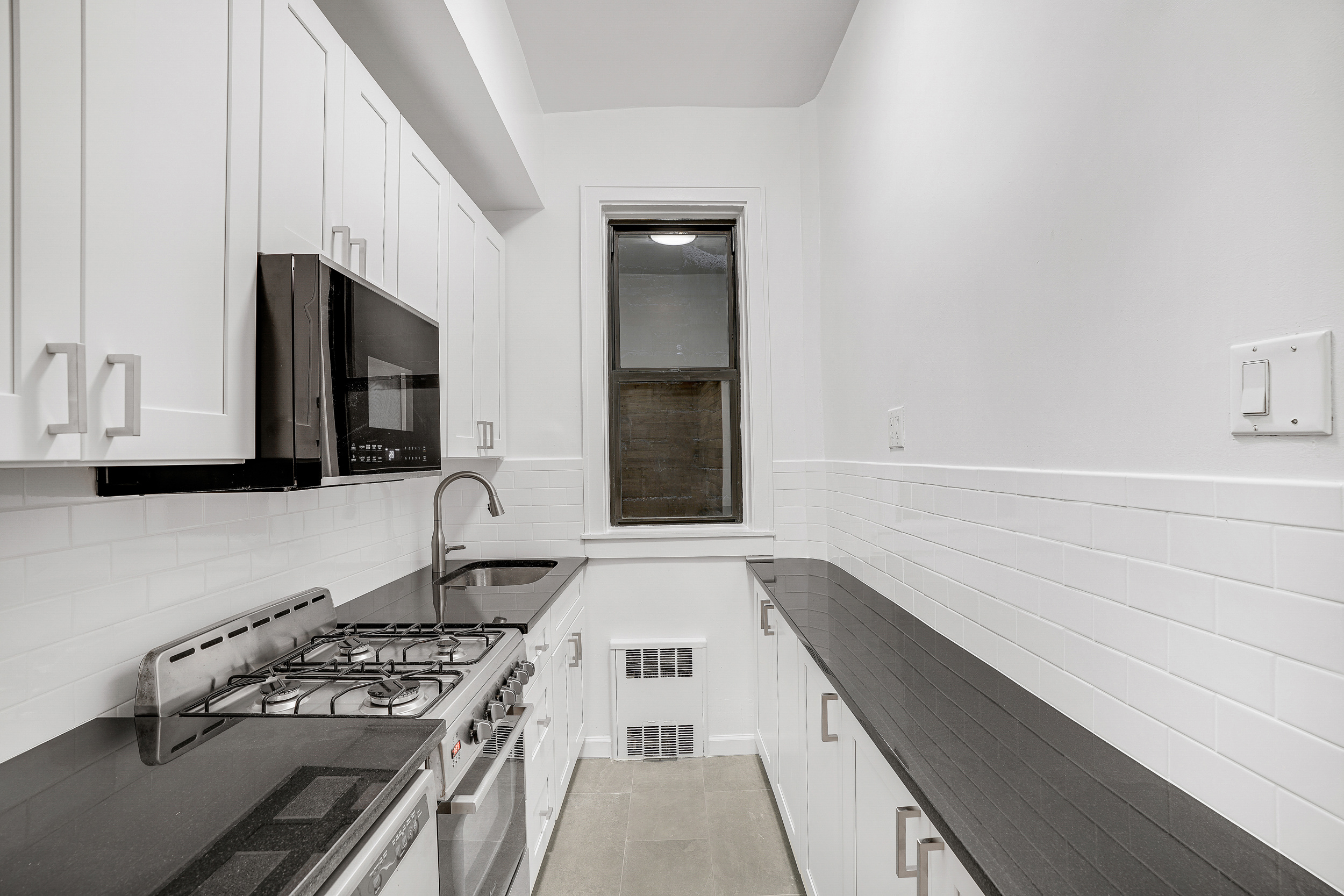 433 East 82nd Street, Unit 1A Manhattan, NY 10028 - Photo 4 of 6 a kitchen with a stove and a sink
