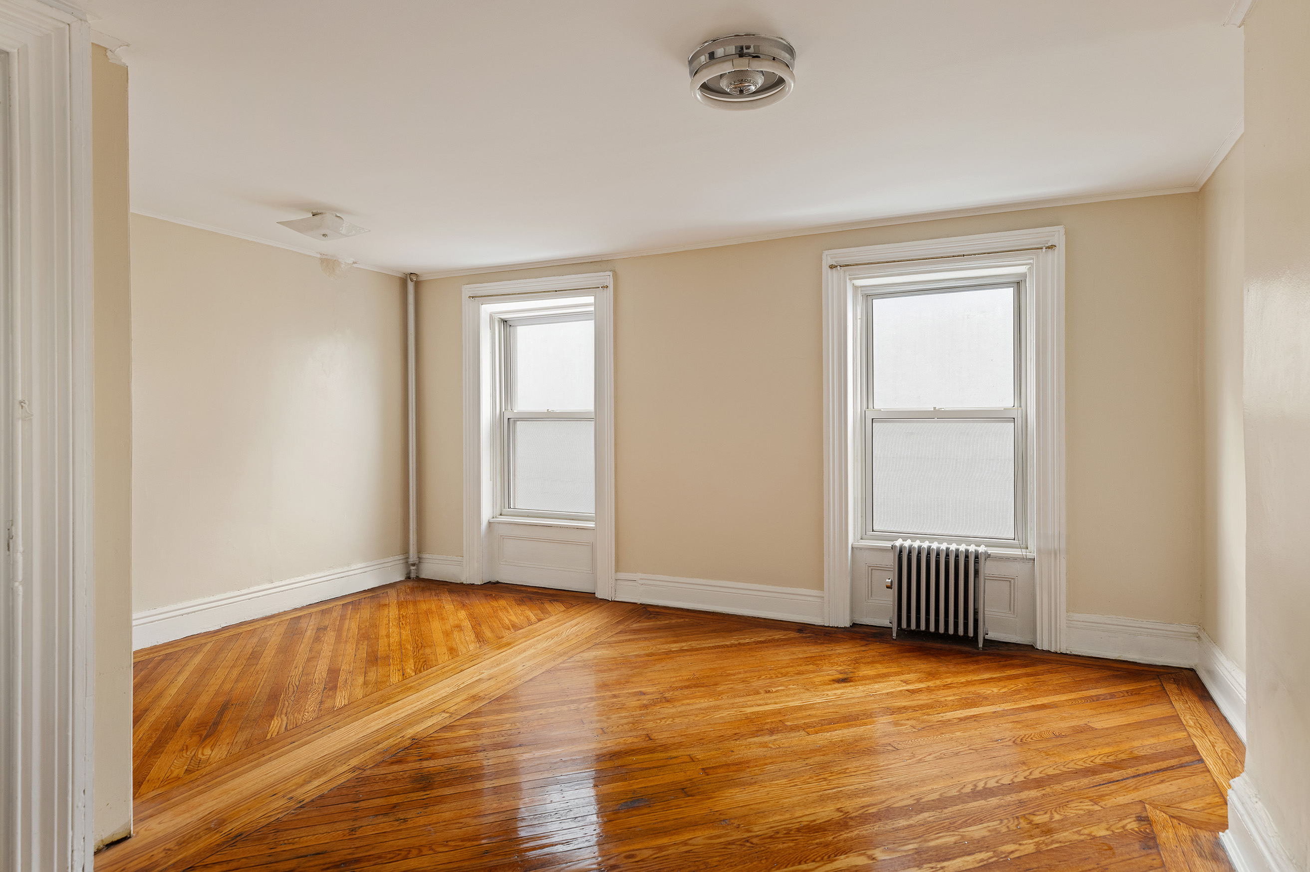 116 Brooklyn Avenue Brooklyn, NY 11216 - Photo 16 of 21 a view of empty room with wooden floor and fan