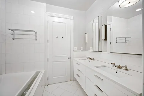 a bathroom with a tub sink and mirror