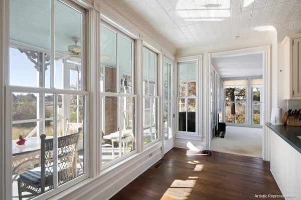 a view of a hallway with wooden floor and windows