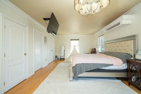 a bedroom with a bed and a chandelier