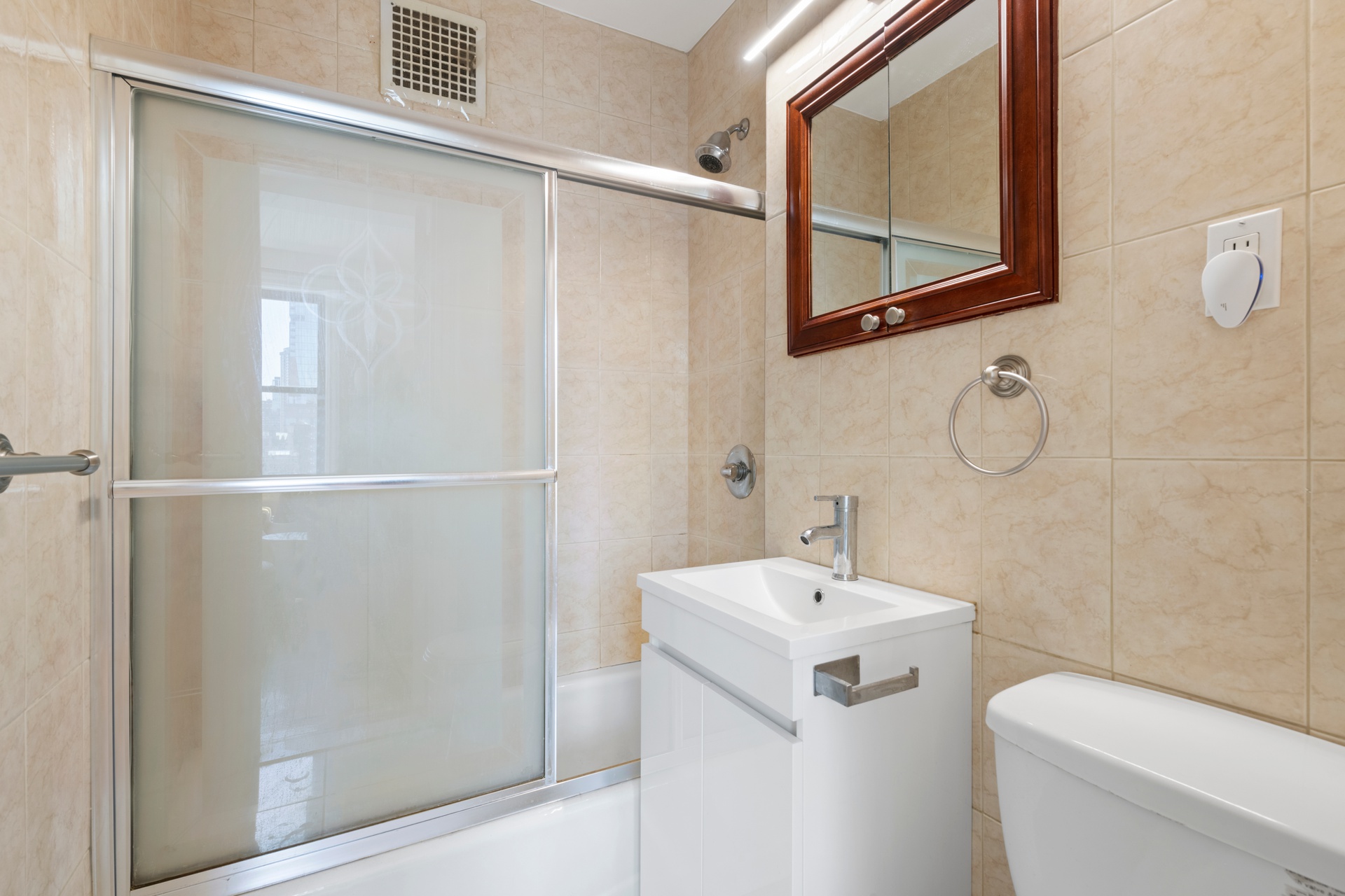 20 West 72nd Street, Unit 1106B Manhattan, NY 10023 - Photo 8 of 10 a bathroom with a sink a mirror a toilet and vanity