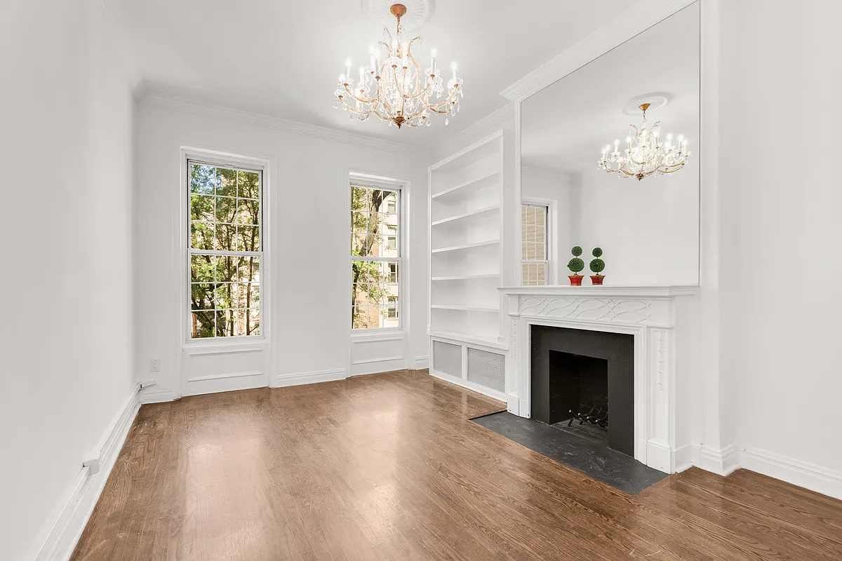 177 East 70th Street Manhattan, NY 10021 - Photo 5 of 14 a view of an empty room with wooden floor fireplace and a window