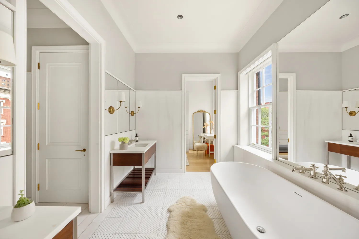 a spacious bathroom with a tub sink and mirror