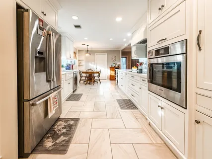 a kitchen with stainless steel appliances kitchen island granite countertop a refrigerator and a stove top oven