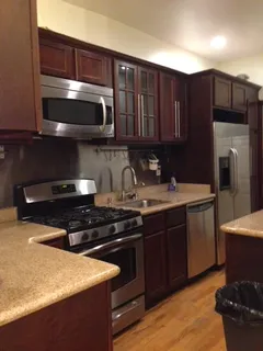 a kitchen with stainless steel appliances wooden cabinets and a stove top oven