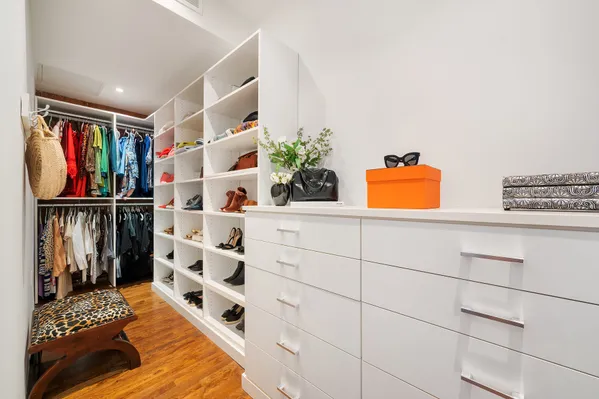 a view of walk in closet and wooden floor