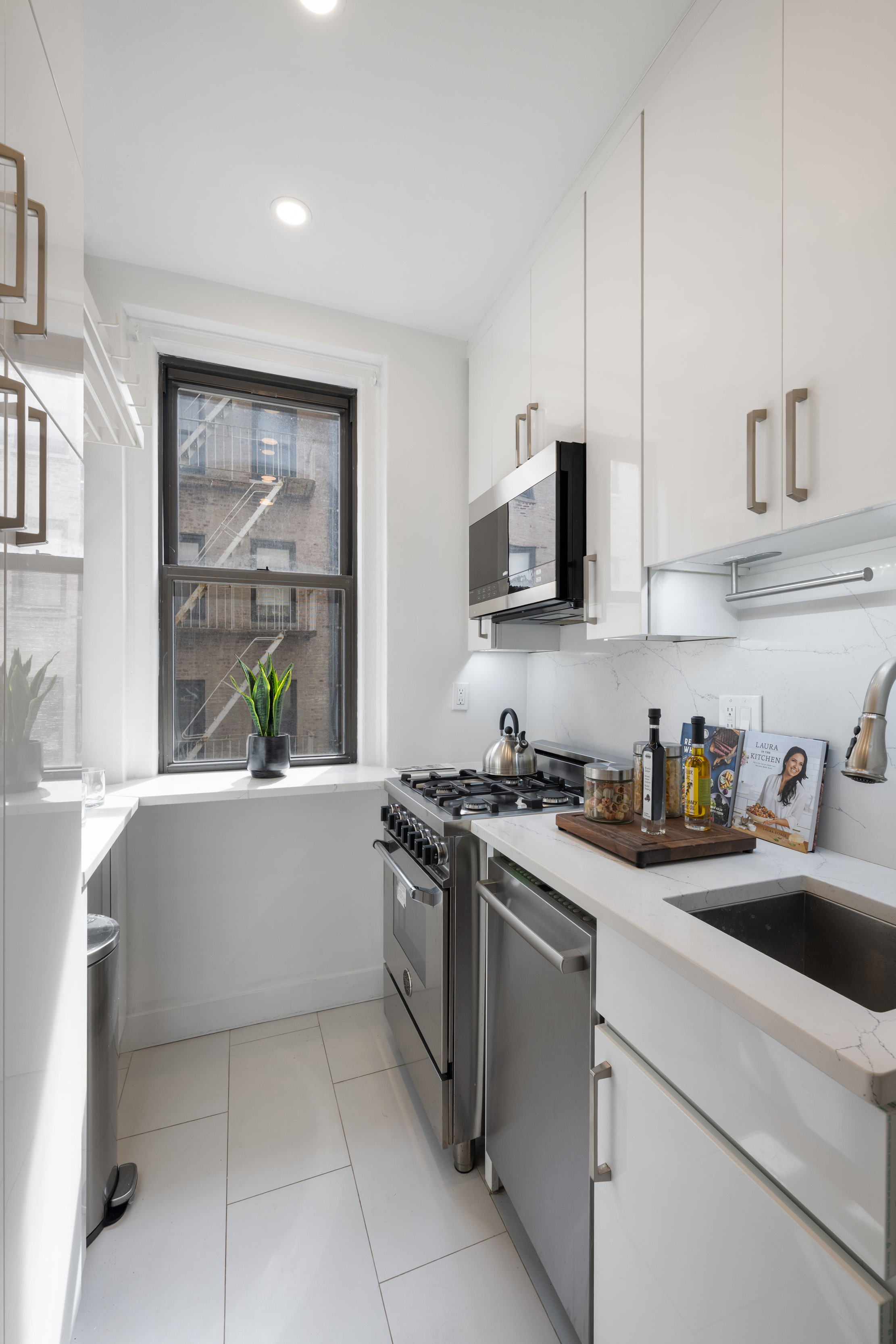 350 Cabrini Boulevard, Unit 7N Manhattan, NY 10040 - Photo 6 of 10 a kitchen with stainless steel appliances a stove a sink and white cabinets