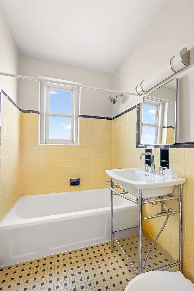 a bathroom with a bathtub a sink a mirror and a shower