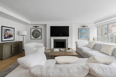 a living room with furniture a flat screen tv and a fireplace