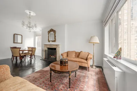 a living room with furniture a fireplace and a large window