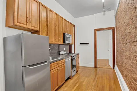 a kitchen with a refrigerator a stove and wooden cabinets