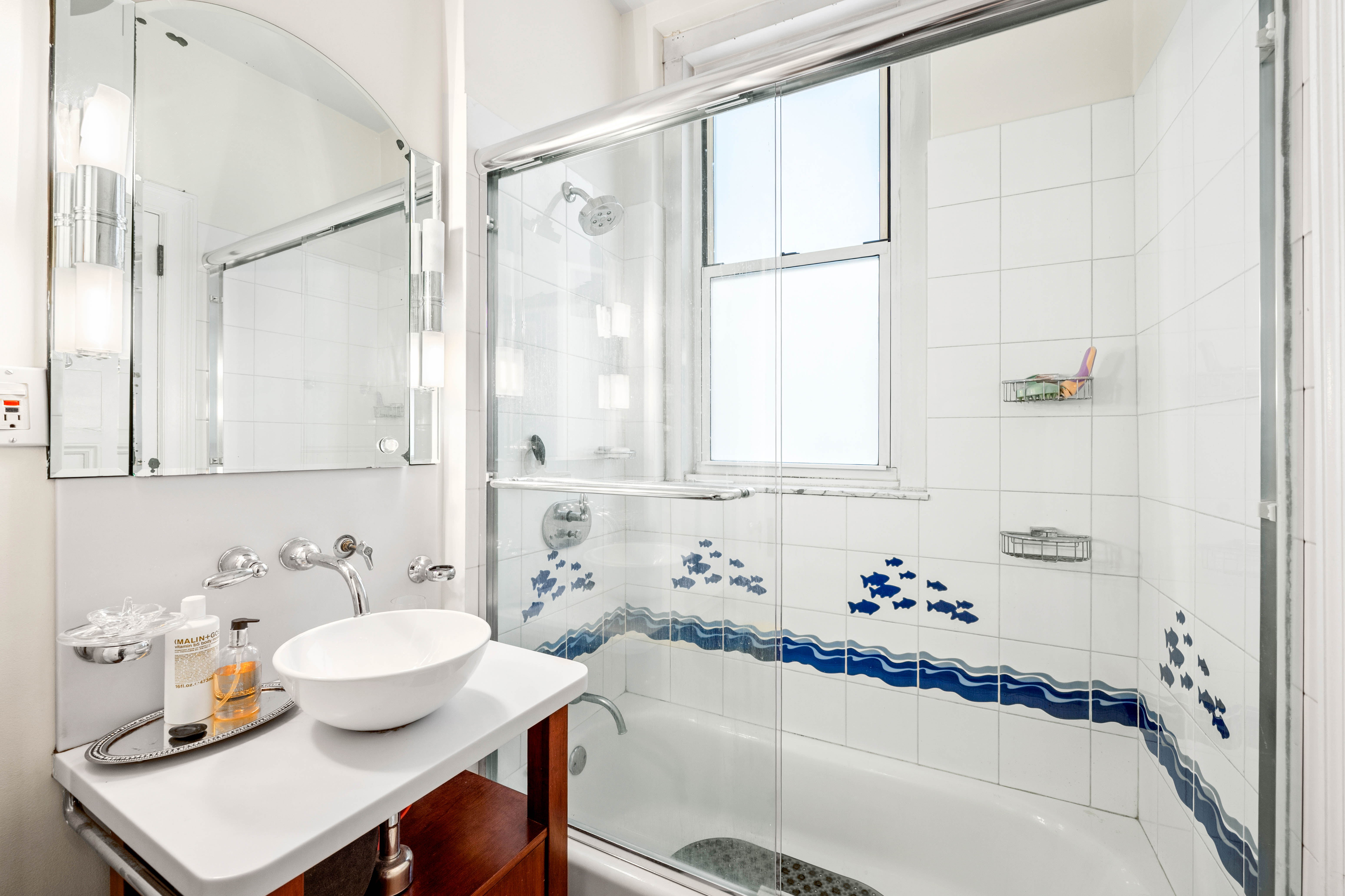 50 West 67th Street, Unit 4F Manhattan, NY 10023 - Photo 8 of 10 a bathroom with a tub sink and a window