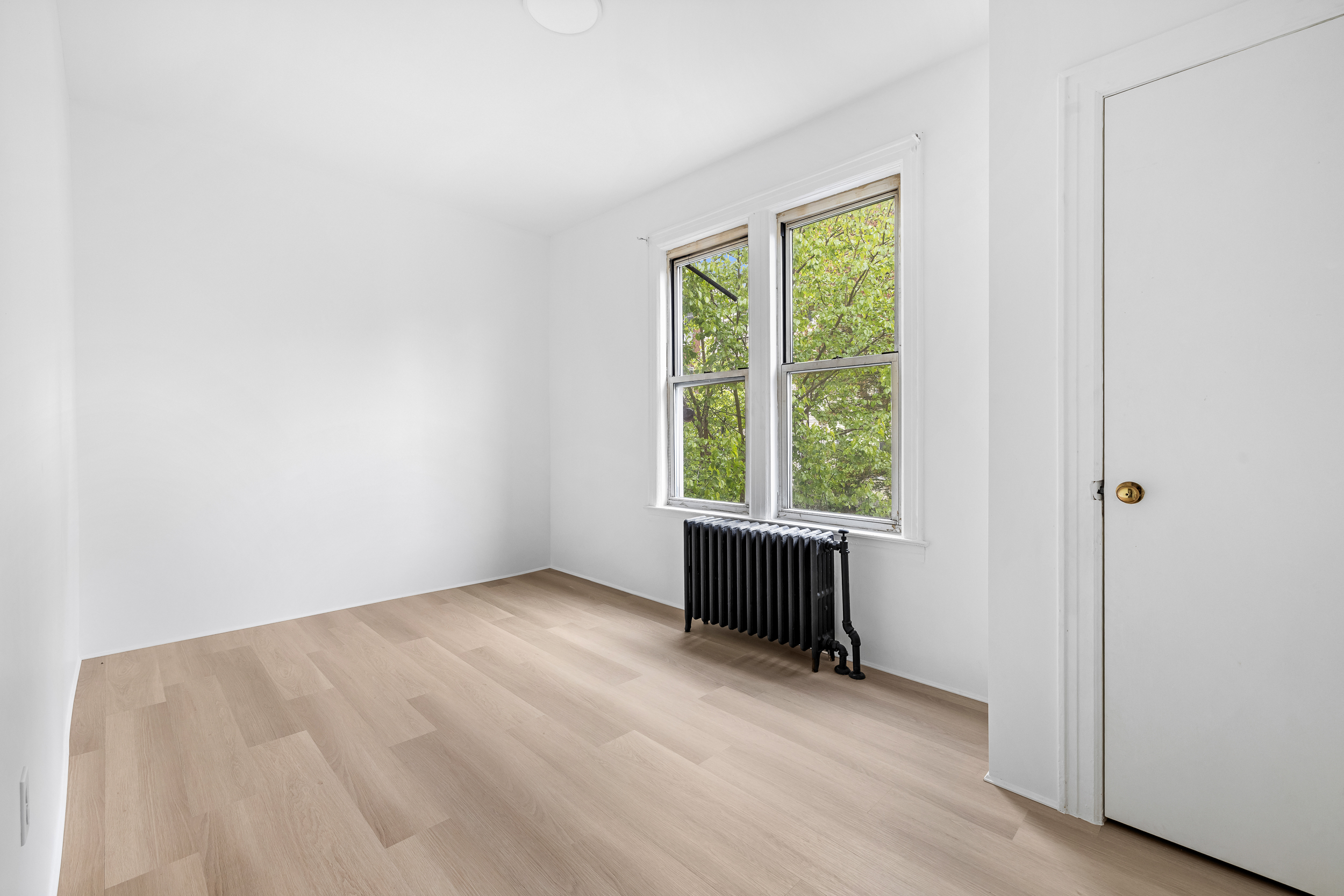 996 Hart Street, Unit 2 Brooklyn, NY 11237 - Photo 4 of 7 an empty room with wooden floor and windows