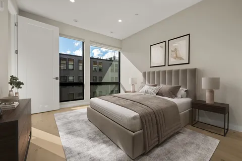 a bedroom with a large bed and a chandelier