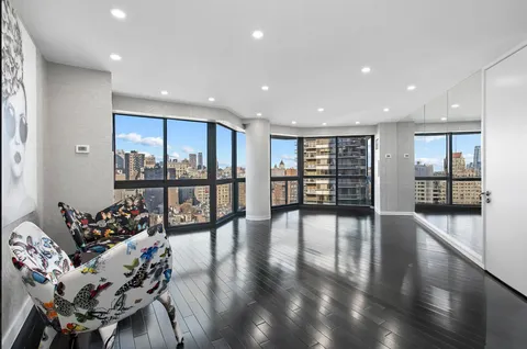 a living room with furniture and large windows