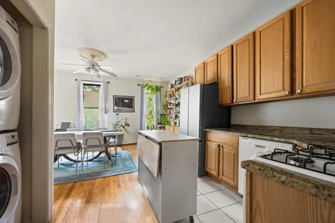 a kitchen with granite countertop a stove a sink and a refrigerator