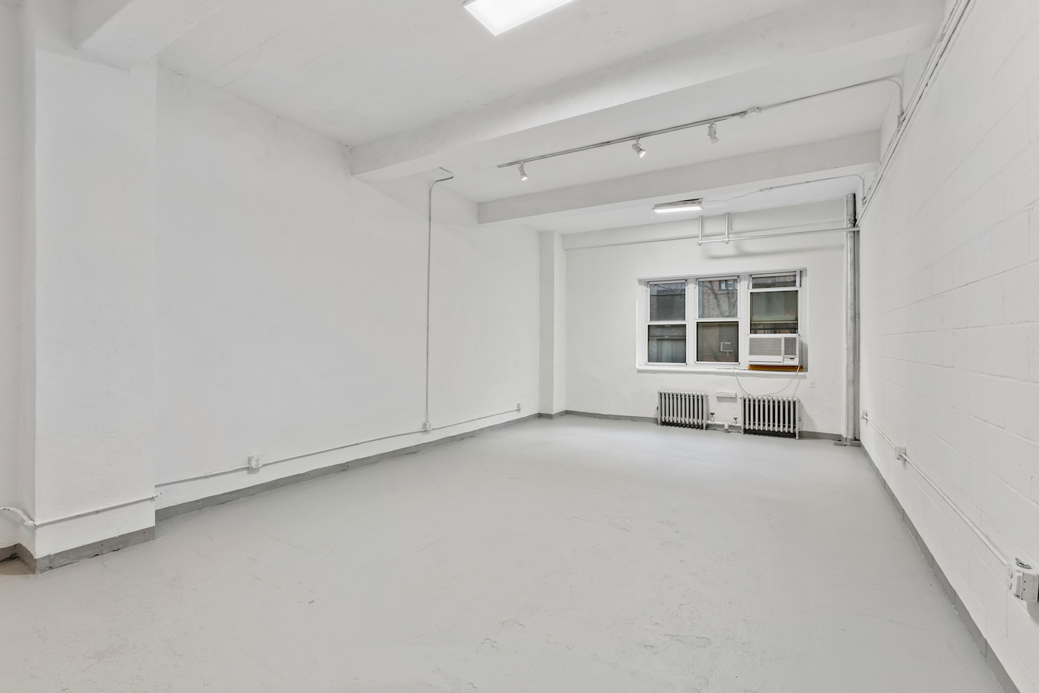 315 East 91st Street, Unit 2E Manhattan, NY 10128 - Photo 5 of 7 an empty room with a fireplace and window