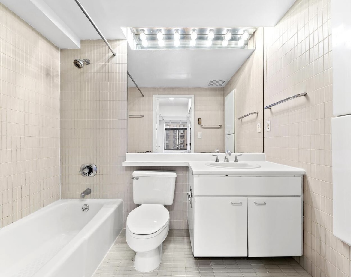 400 East 70th Street, Unit 807 Manhattan, NY 10021 - Photo 4 of 9 a bathroom with a sink a toilet a mirror and bathtub
