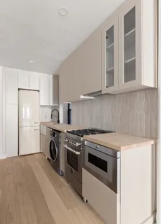 a kitchen with a stove top oven and cabinets