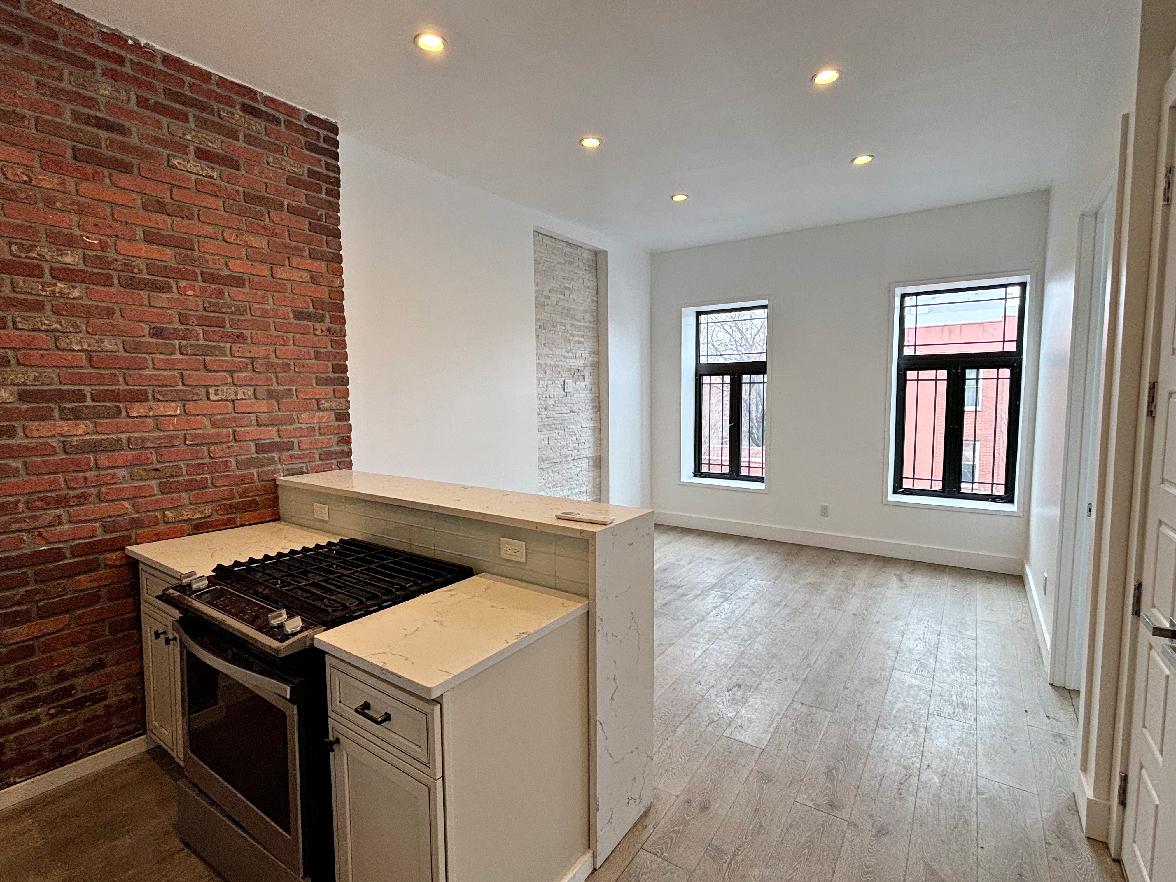 385 Nostrand Avenue, Unit Undisclosed Brooklyn, NY 11216 - Photo 15 of 27 a kitchen that has a stove and wooden floor
