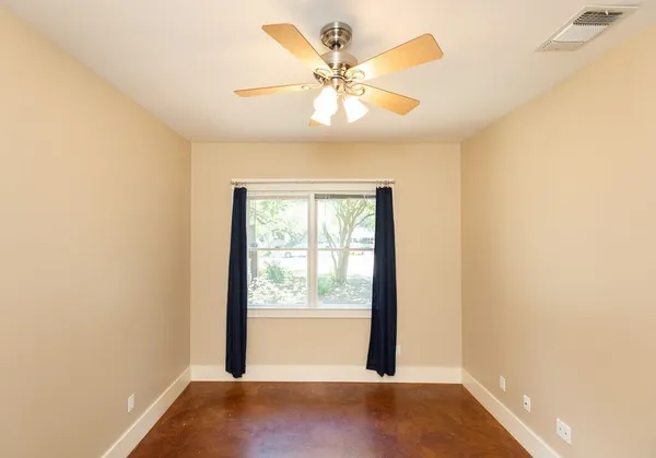 an empty room with a window and a ceiling fan
