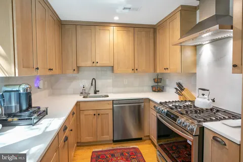 a kitchen with a sink stove top oven and cabinets