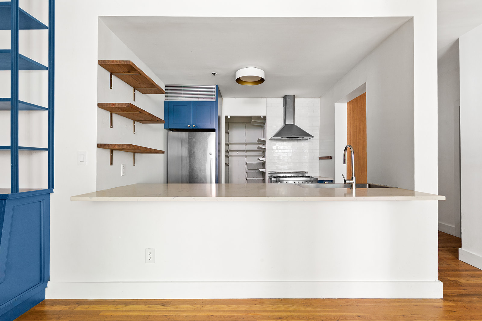 372 Dekalb Avenue, Unit 1I Brooklyn, NY 11205 - Photo 3 of 11 a large white kitchen with kitchen island and a wooden floor