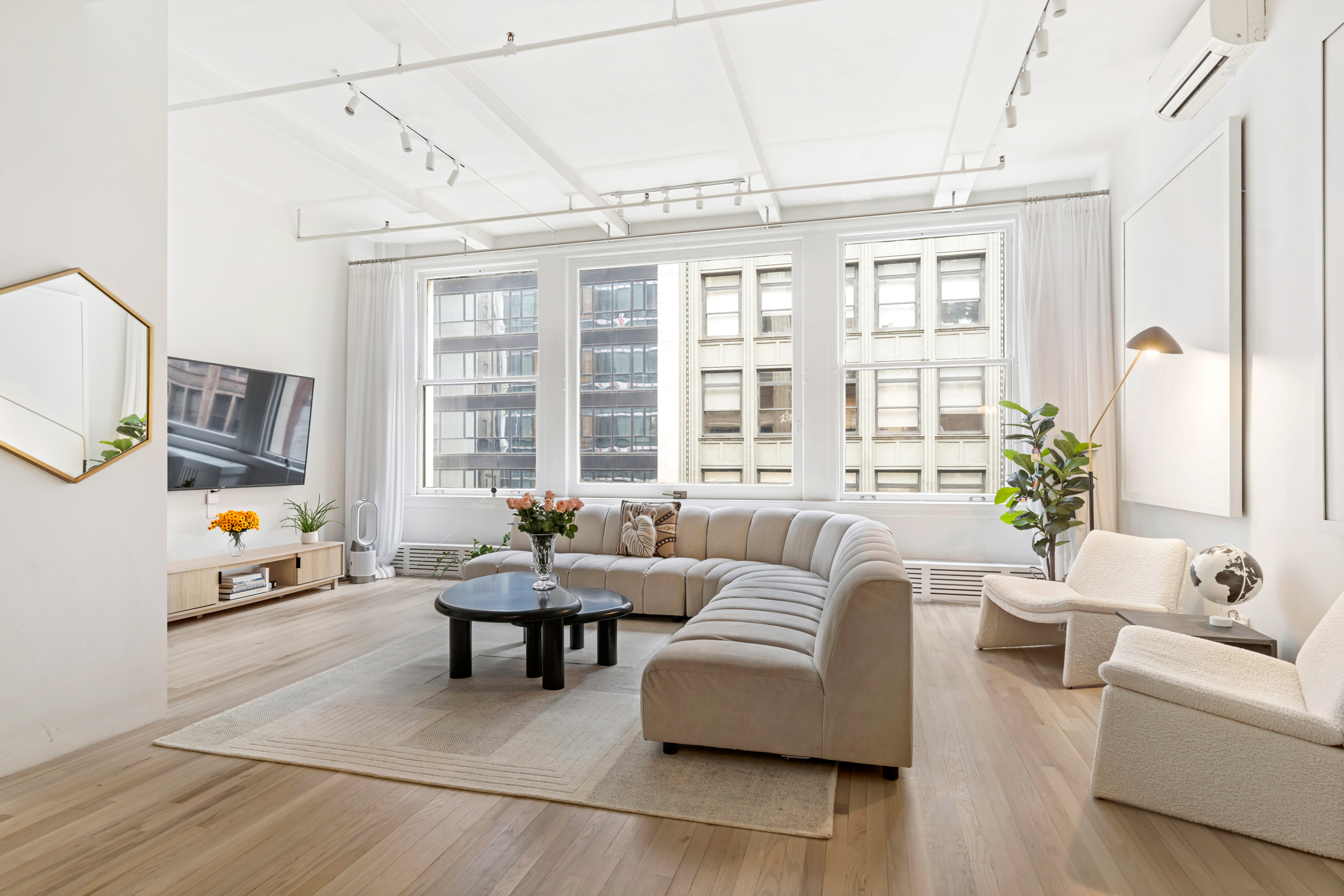 28 West 38th Street, Unit 6E Manhattan, NY 10018 - Photo 1 of 11 a living room with furniture and a large window