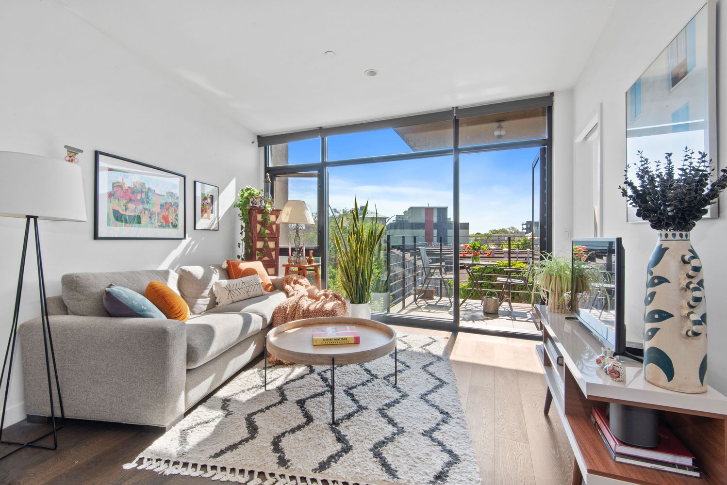 a living room with furniture a lamp and a floor to ceiling window