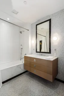 a bathroom with a granite countertop sink mirror and bathtub