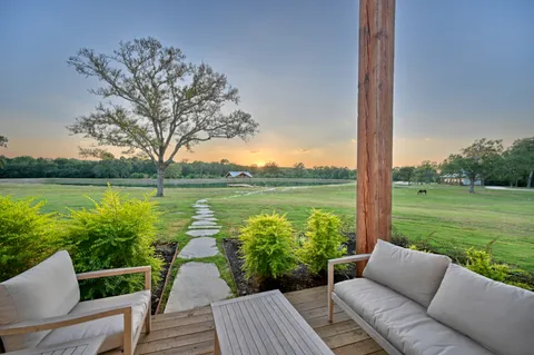 a view of a big house with a big yard and large trees