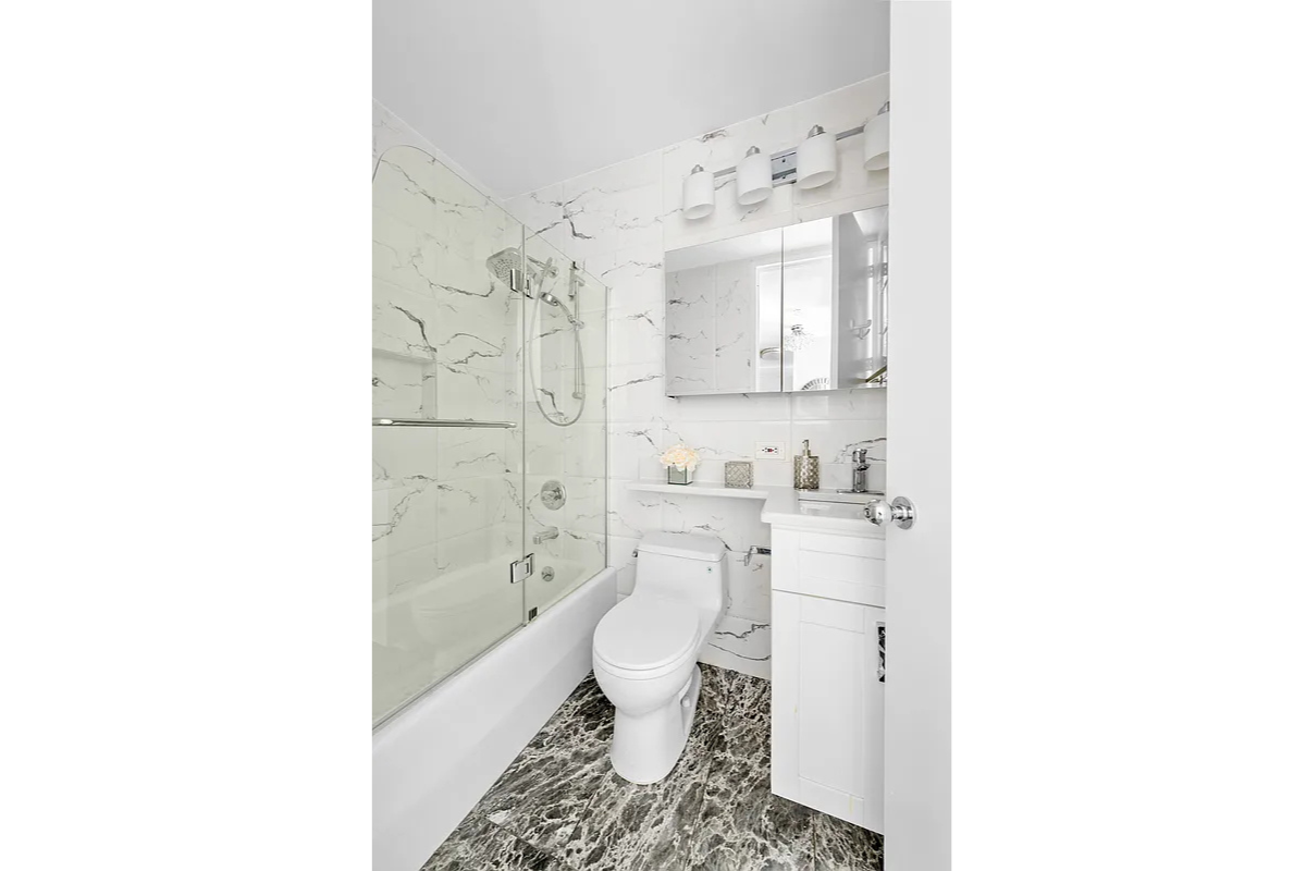 300 East 62nd Street, Unit 1001 Manhattan, NY 10065 - Photo 6 of 10 a bathroom with a toilet a sink and a bathtub