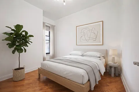 a bedroom with a bed and a potted plant