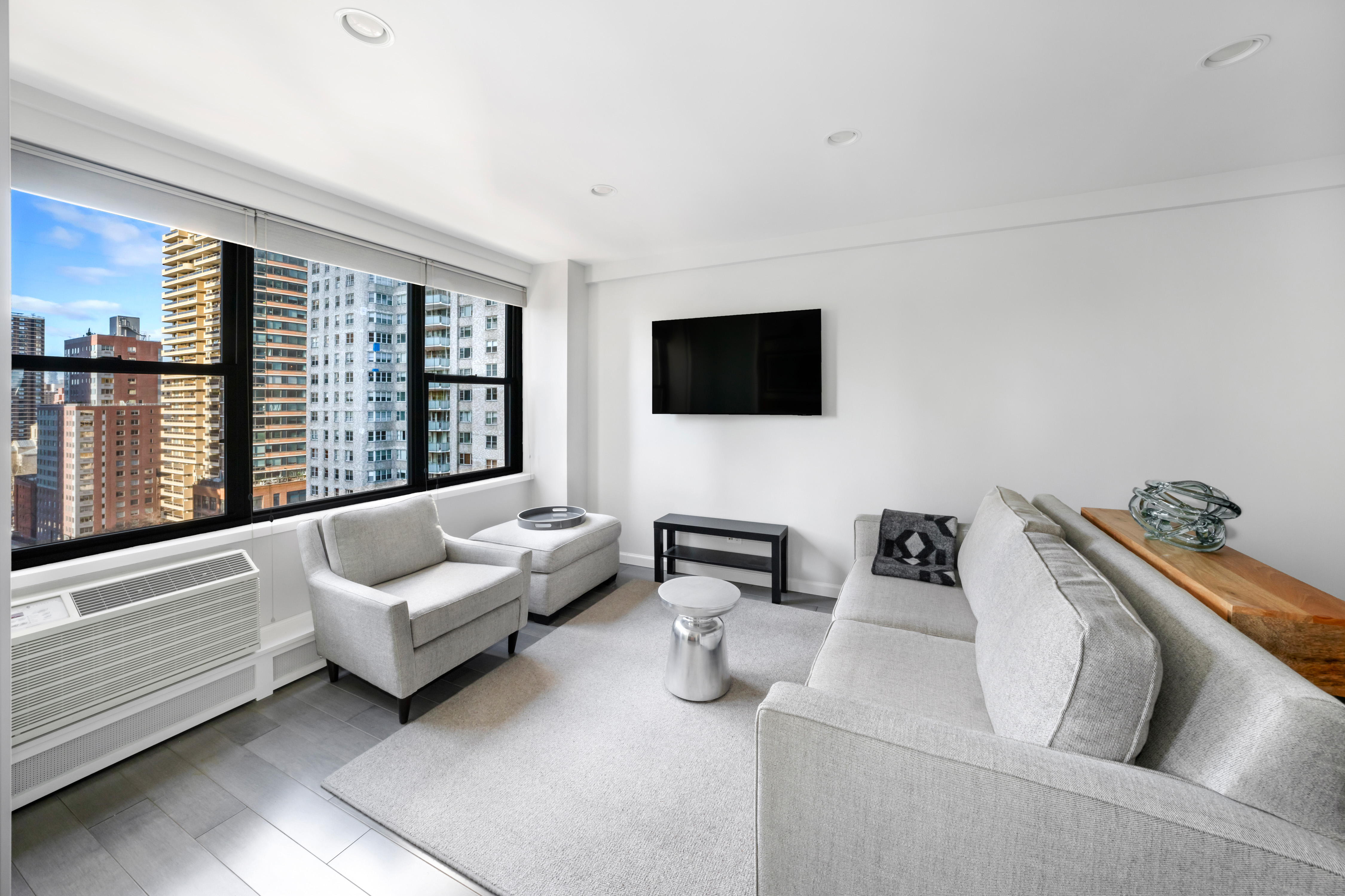 2 Tudor City Place, Unit 9OS Manhattan, NY 10017 - Photo 3 of 11 a living room with furniture and a flat screen tv