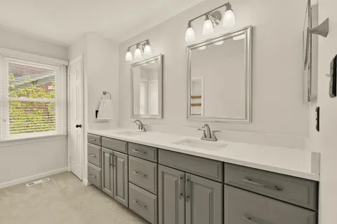 a bathroom with double sink and a mirror