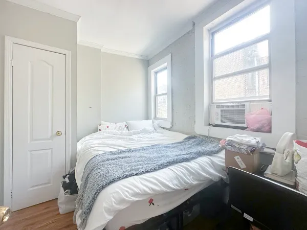 a bedroom with a bed and wooden floor