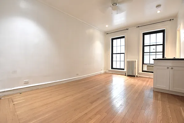 172 5th Avenue, Unit 2F Manhattan, NY 10010 - Photo 4 of 10 an empty room with wooden floor and windows