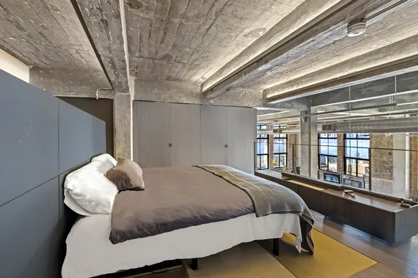 a bedroom with a bed and wooden floor