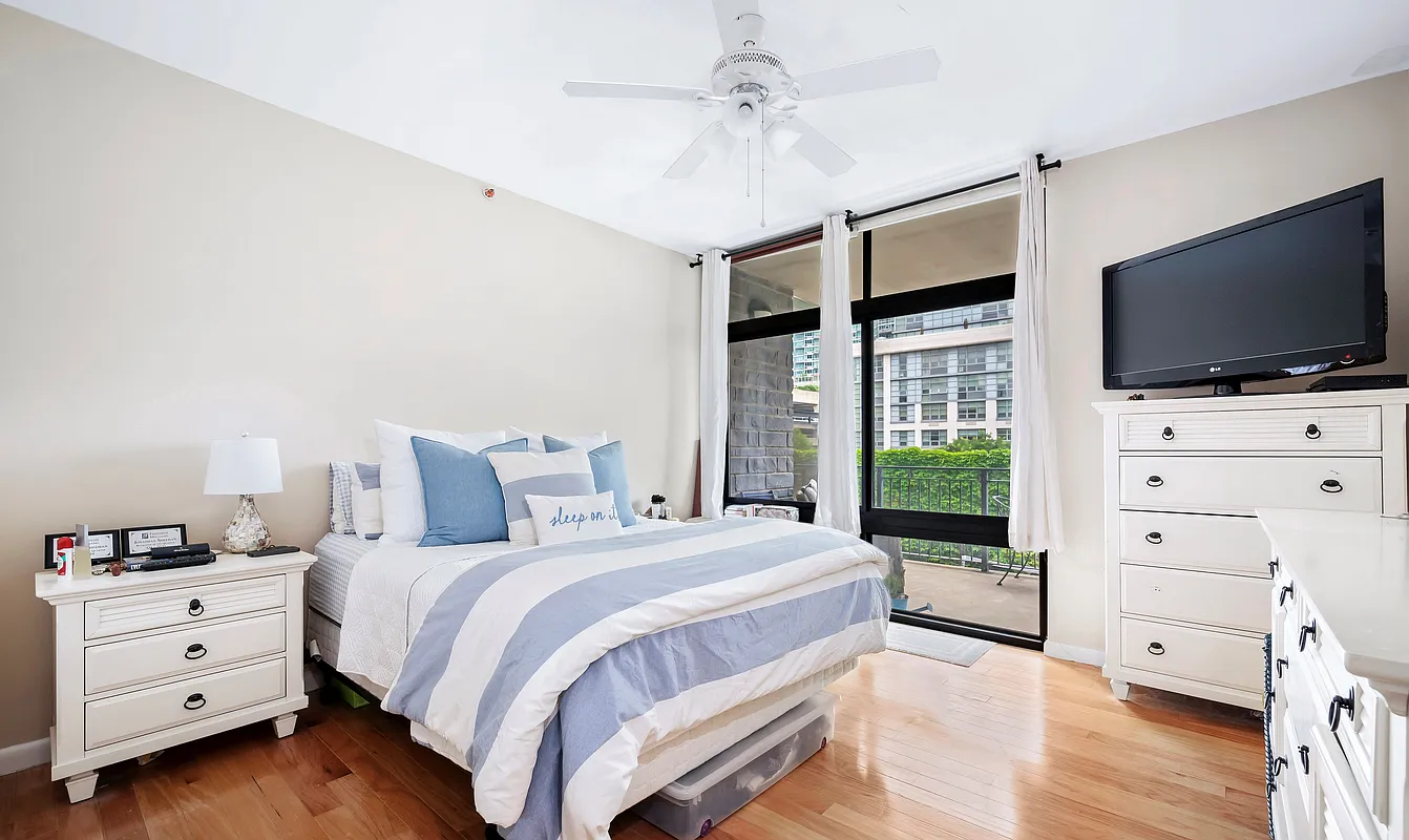 48-21 5th Street, Unit 3H Queens, NY 11101 - Photo 5 of 10 a bedroom with a bed and a flat screen tv