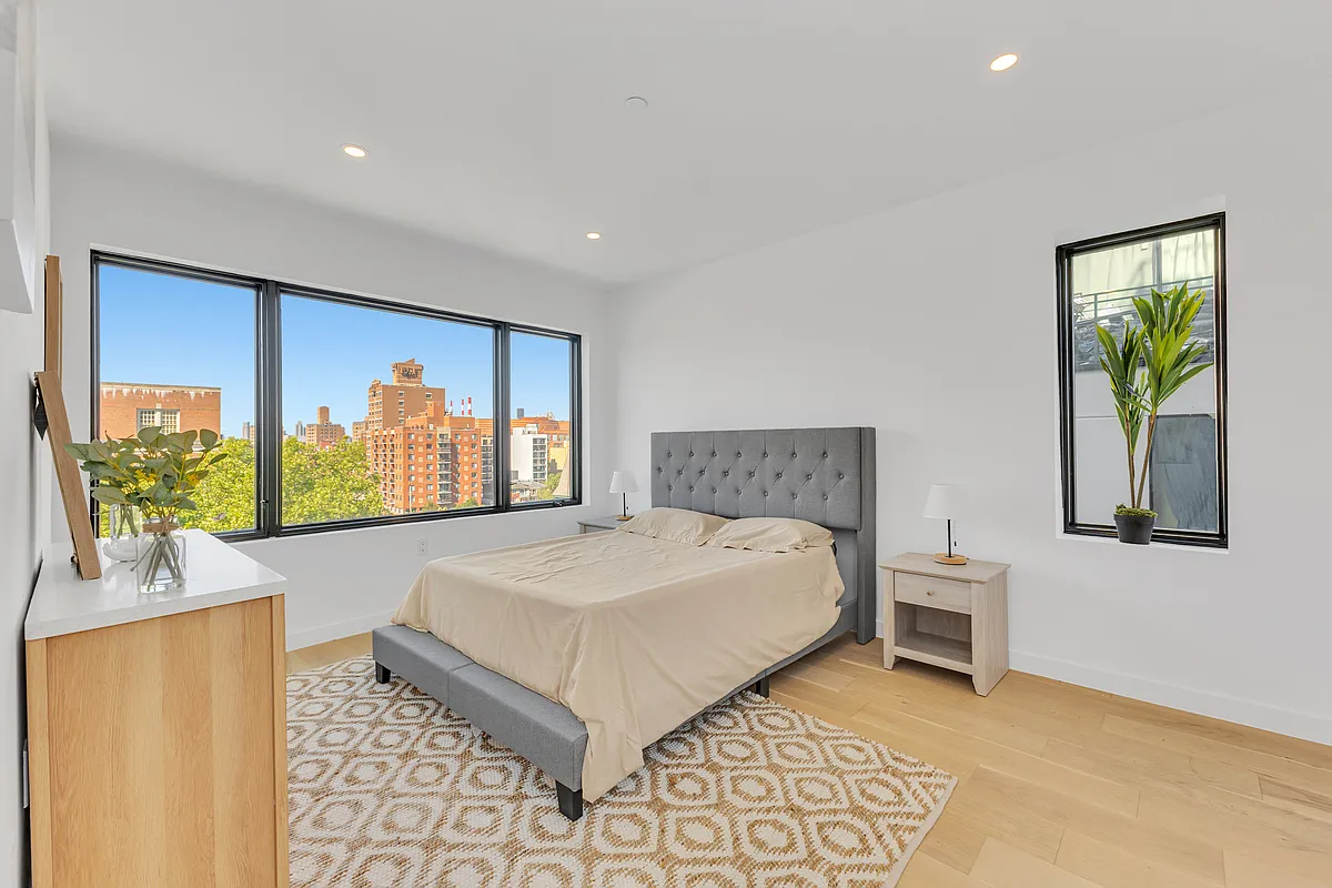21-10 31st Avenue, Unit 6R Queens, NY 11106 - Photo 9 of 17 a bedroom with a bed and a dresser next to a window