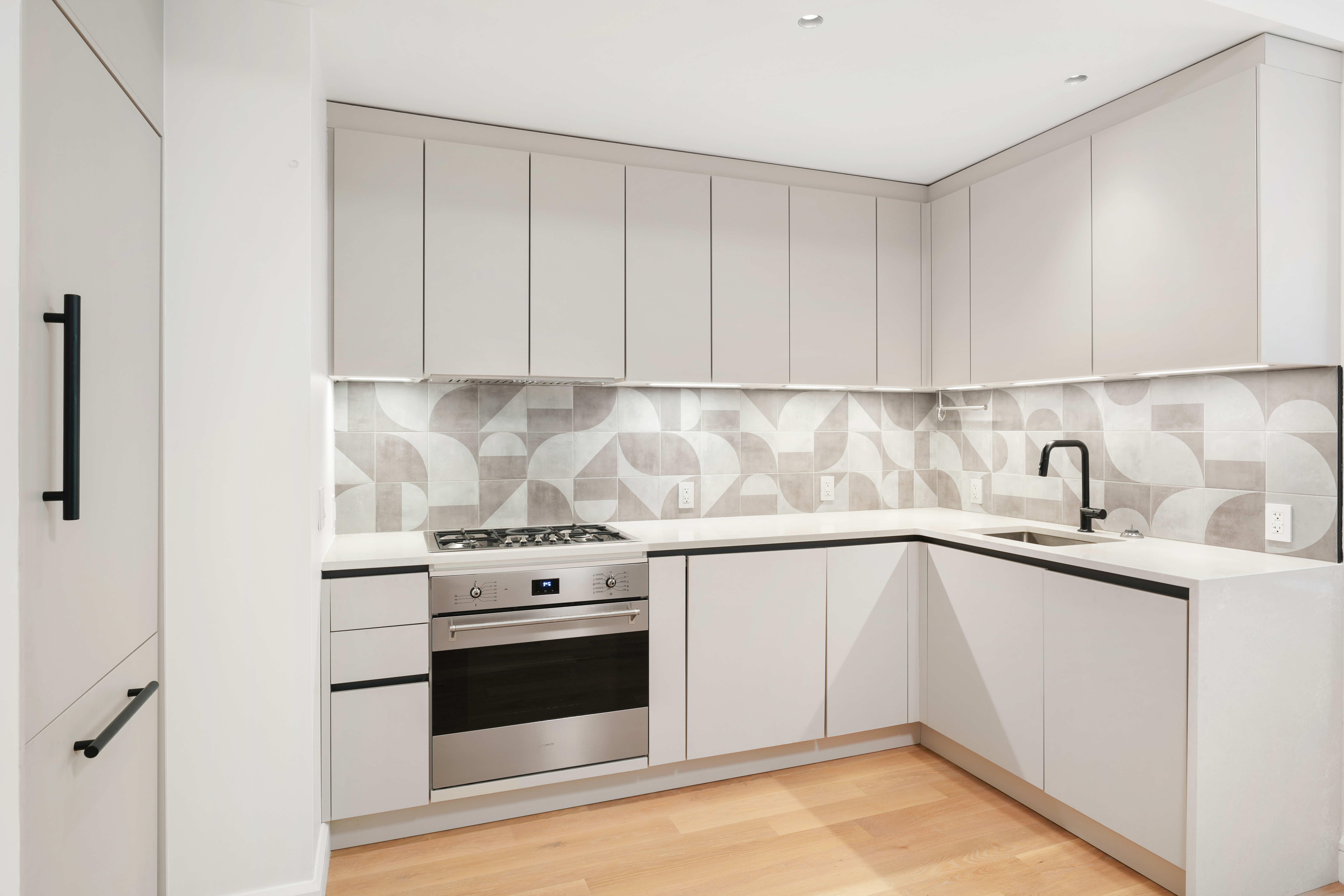 176 West 87th Street, Unit 1H Manhattan, NY 10024 - Photo 5 of 19 a kitchen with granite countertop white cabinets and white appliances