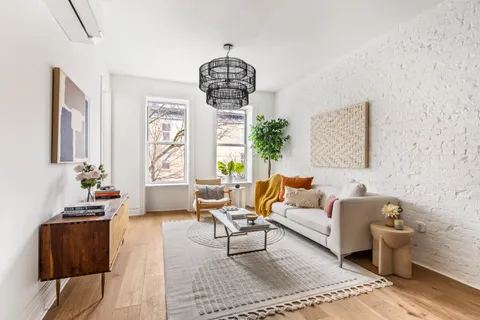 a living room with furniture chandelier and a window